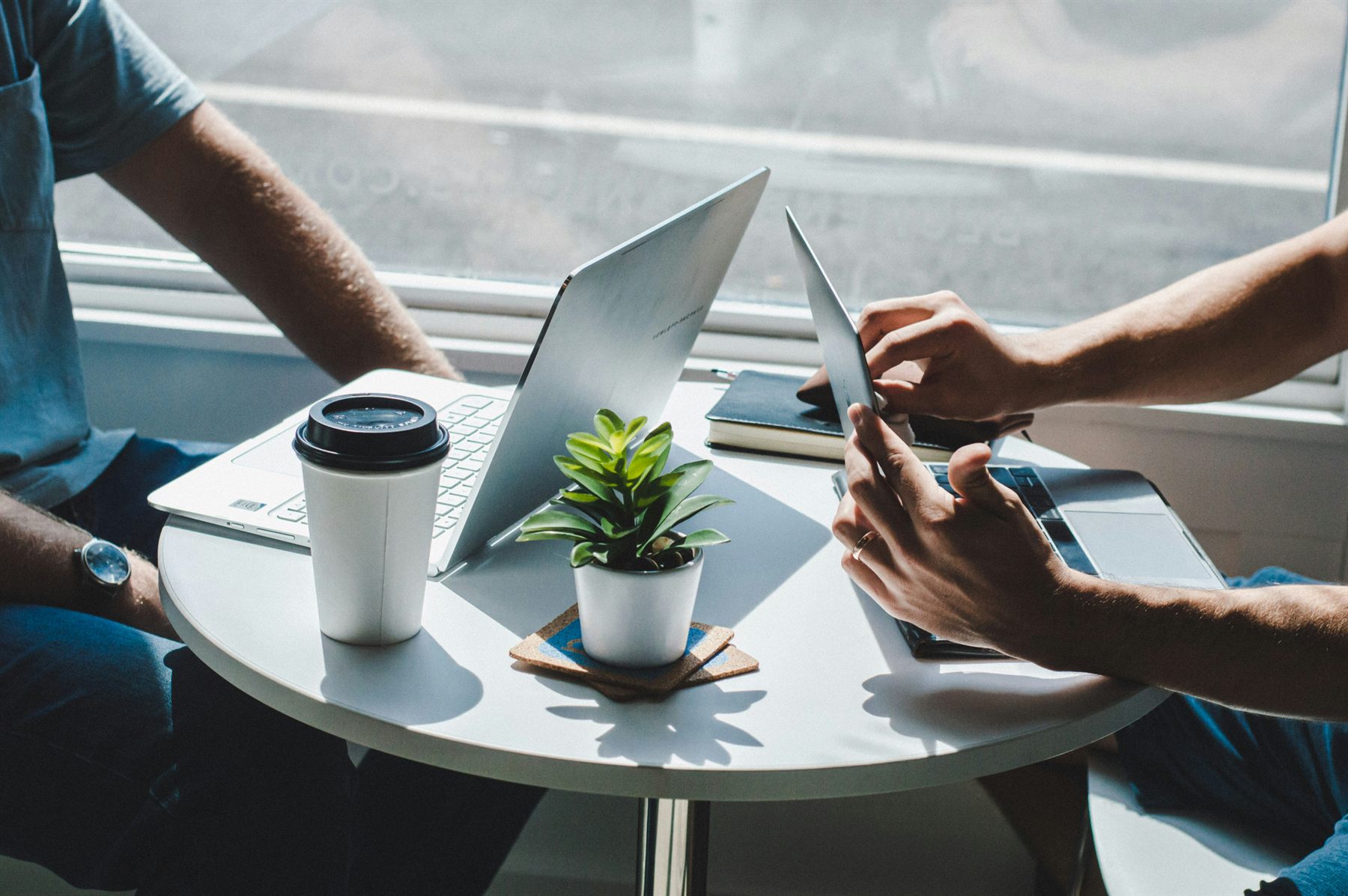 A client consultation with a laptop, notebook, and coffee on the table