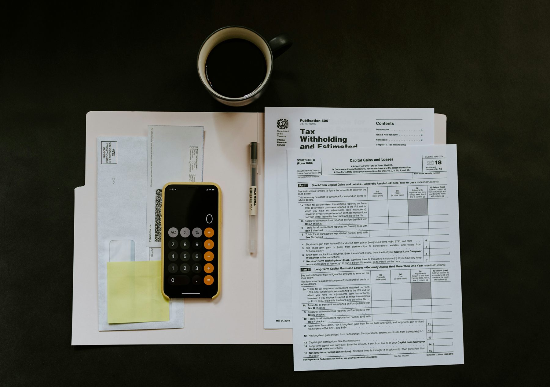 Tax forms, a calculator, and paperwork arranged for review